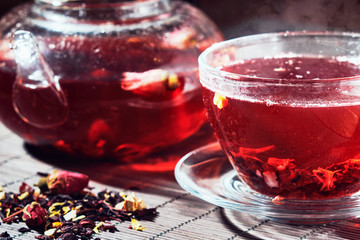 Fresh herbal tea in a glass teapot and a cup
