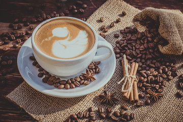 A cup of latte coffee and coffee beans. Toning.