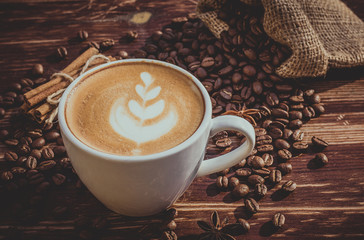 A cup of latte coffee and coffee beans. Toning.