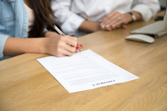 Woman signing business contract, female hand putting written signature on legal document in lawyers office, businesswoman making agreement, taking bank loan or insurance concept, close up view
