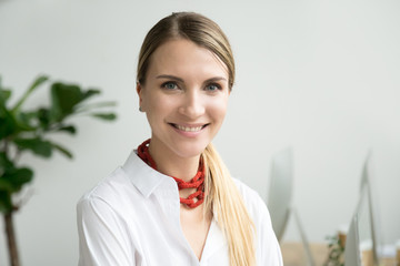 Portrait of young businesswoman, attractive happy skilled professional woman looking at camera in...