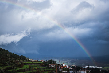 Naklejka na ściany i meble Rainbow in the mountains. Strong rainbow after rain. Fairyland.