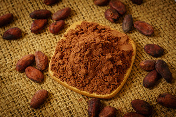 Cacao powder and cocoa beans on burlap