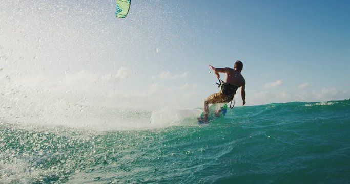 Kitesurfing at sunset in slow motion, kiteboarder carving across the water