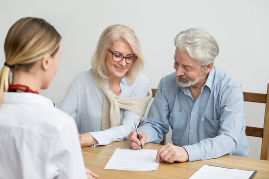 Aged couple signing contract making investment at meeting with financial advisor, happy senior family put signature on business document taking bank loan, retired smiling customers buying insurance
