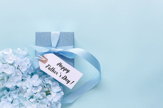 Top view aerial image of decoration Happy Fathers day holiday background concept.Flat lay dad white card with blue flower on modern beautiful  blue paper at home office desk.Free space for design.