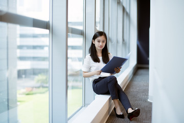 office lady hold folders by the window
