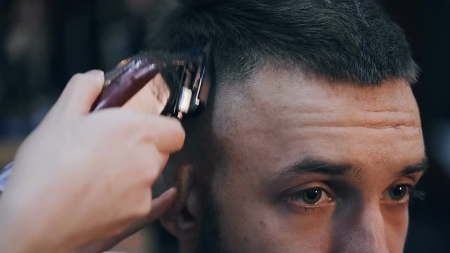Men's hairstyling and haircutting in a barber shop or hair salon. Grooming the hair. Barbershop. Woman hairdresser doing haircut adult men in the men's hair salon. Haircutter in the workplace