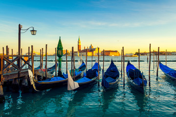 Fototapeta na wymiar Venice with famous gondolas in lagoon at sunrise