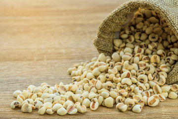 Job's tears in the sack on wooden teble.