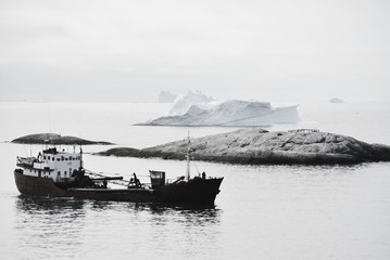 black and white - lonely fishing boat in the disko bay - Greenland Ilulissat - ocean with icebergs...