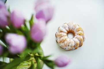 Lemon Easter cake and tulips on a white table
