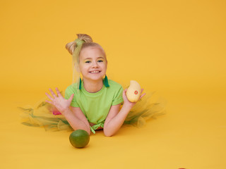 A little girl dressed in a mango flower costume.