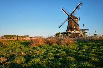 Naklejka na ściany i meble Windmills at Zaanse Schans in Holland on sunset. Zaandam, Nether