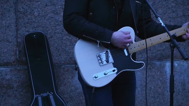 rock music, unrecognizable street musician playing guitar slow motion