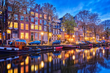 Amterdam canal, boats and medieval houses in the evening