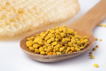 Bee pollen in a wooden spoon and a honeycomb. Beekeeping products. Apitherapy.
