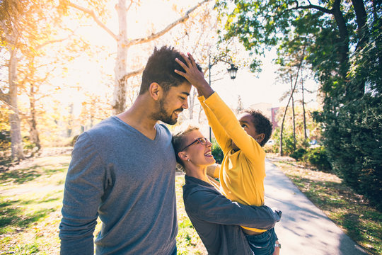 Happy Young Mixed Race Couple Spending Time With Their Daughter Having Fun