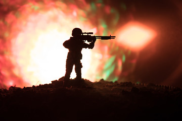 Army sniper with large-caliber sniper rifle seeking killing enemy. Silhouette on sky background....