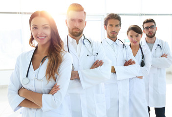 Portrait of medical team standing with arms crossed in hospital