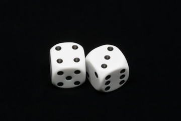 The dices are cast - two dices on a black background showing a total of seven eyes 