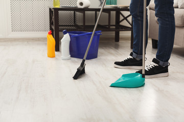 Unrecognizable man cleaning home, sweeping