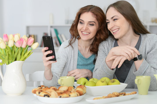 two female friends looking at smartphone