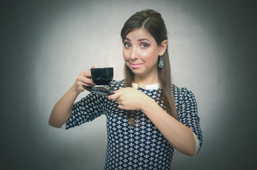 Coffee break. Coffee time. Lunch break. Happy smiling woman holding in hands a cup of coffee isolated on gray background.