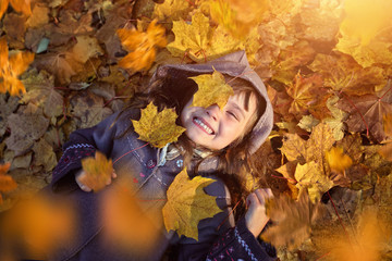 Young girl lying in colorful leaves