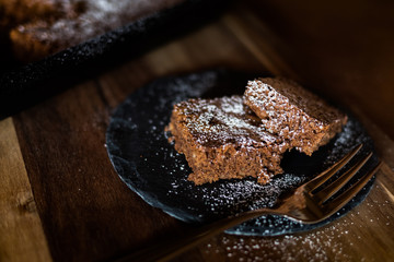 Saftiger Kuchen aus Zartbitterschokolade mit Mandeln vom Blech angerichtet auf einer Schieferplatte...