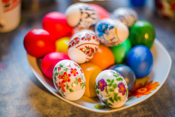 Fototapeta na wymiar Plate with colorful Easter eggs. Easter eggs on table. Easter background.