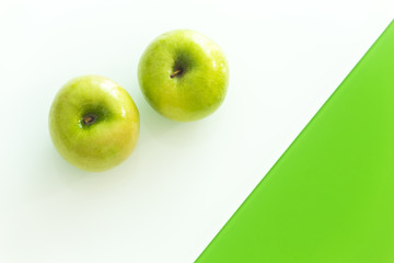 Green apple on the white-green glass background.