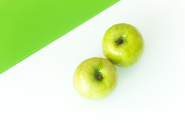 Green apple on the white-green glass background.