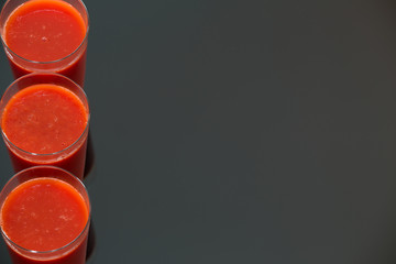 tomato juice isolated on black glass background.
 / place for text