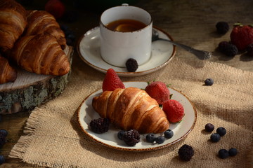 The freshly baked croissants for breakfast with berries and green tea 