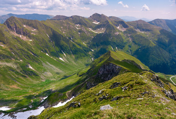 Naklejka premium ridge with grassy slopes and cliffs. Southern Carpathian mountains in a far distance. beautiful summer scenery of Romania