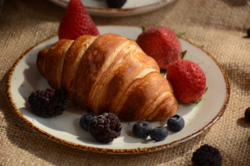 The freshly baked croissants for breakfast with berries and green tea 