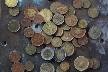 a bunch of various coins on a copper plate