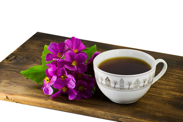 Cup of fruit tea with phlox. Cup of tea and flowers on a wooden board.