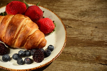 The freshly baked croissants for breakfast with berries and green tea 