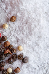 Composition of bay laurel leaf with peppercorn and salt isolated on dark background, top view, close-up, selective focus