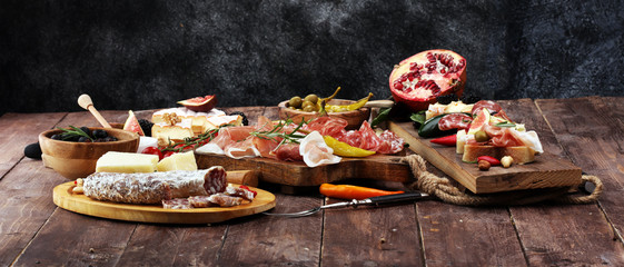 Italian antipasti wine snacks set. Cheese variety, Mediterranean olives, pickles, Prosciutto di Parma and salami
