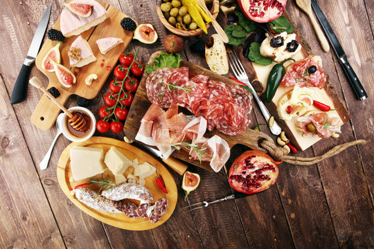 Italian antipasti wine snacks set. Cheese variety, Mediterranean olives, pickles, Prosciutto di Parma and salami