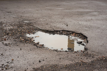 deep and dangerous potholes in UK roads full of water