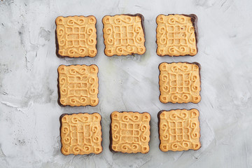 Square biscuits arranged in pattern on light textured background, close-up, shallow depth of field, selective focus.