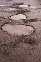 deep and dangerous potholes in UK roads full of water