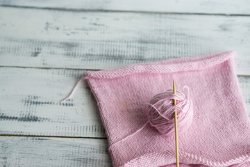 knitted pink tangle on wooden background