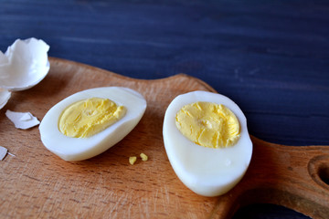 Sliced eggs, eggs shell on a wooden board. Macro food photography. Homemade food still life.