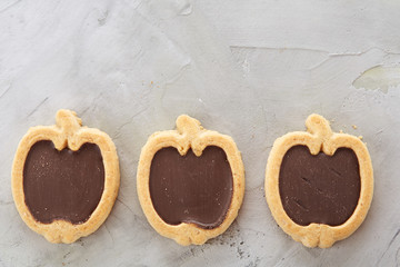 Apple shaped biscuits arranged in rows on light textured background, close-up, shallow depth of field, selective focus.