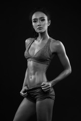 Fototapeta na wymiar Sporty young girl in sportswear exercising black and white
